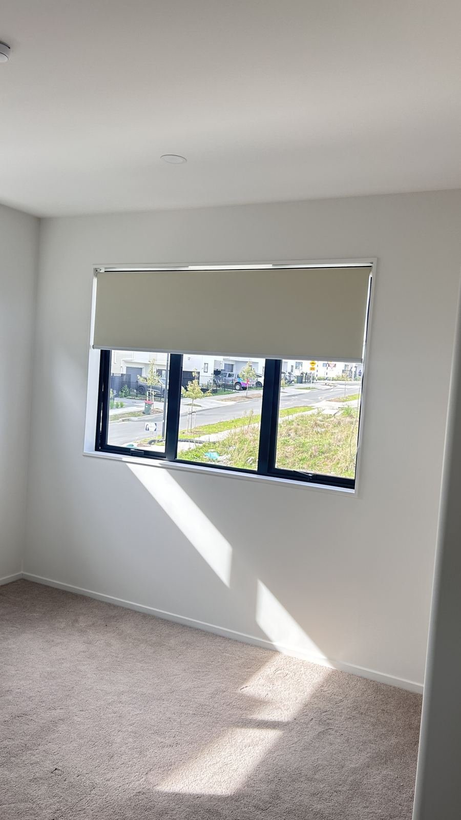 Roller blind with morning sun and street view