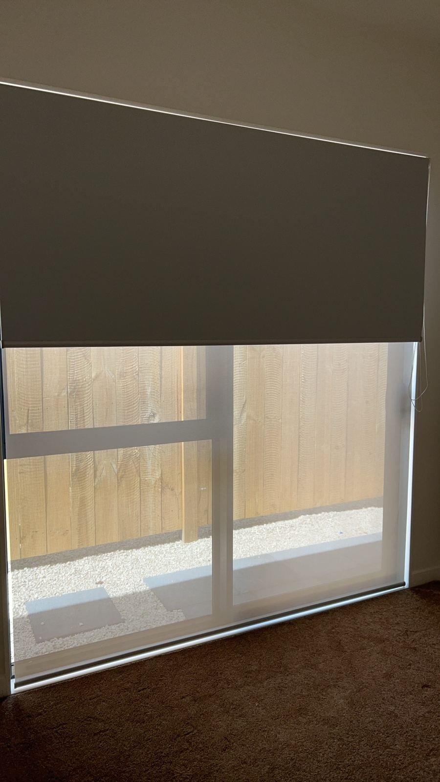 Double roller blind: blockout over sunscreen on a sliding door